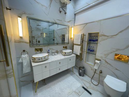 a marble bathroom with a sink and a toilet at Luxury 5 BR Villa with Pool,Cinema Lekki in Lekki
