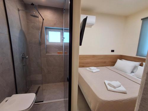 a small bedroom with a shower and a bed at Villa Maroula in Afantou