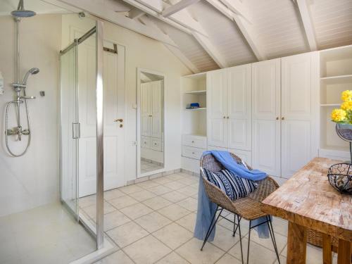 a bathroom with a shower and a table and chairs at GK Beach Hotel in Kalyves