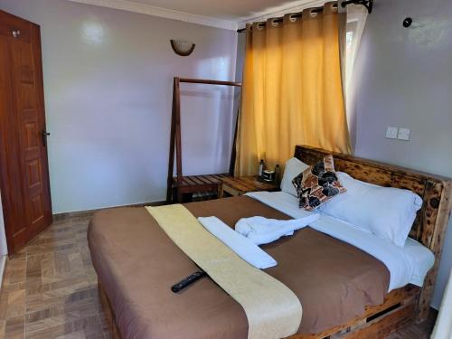 a bedroom with a large bed with towels on it at Pazuri Ark Gardens in Thika
