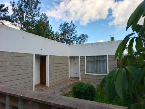 a house with a white wall at Pazuri Ark Gardens in Thika
