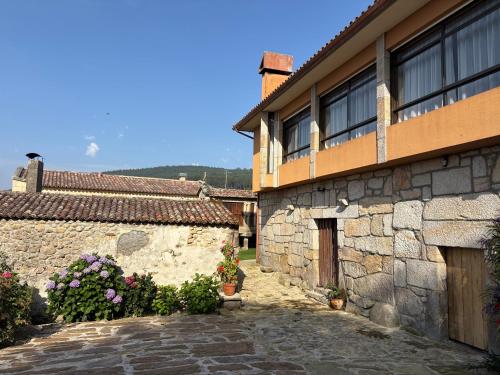 a stone building with flowers in front of it at Casa de Gándara in Baiona
