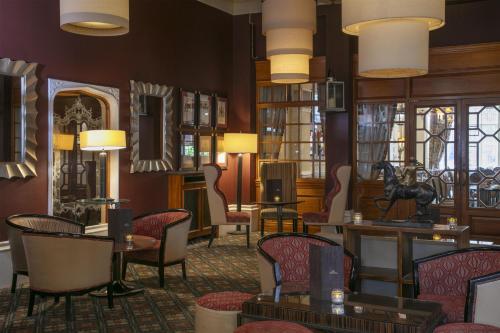 a lobby with chairs and tables and lamps at Best Western Plough and Harrow Hotel in Birmingham