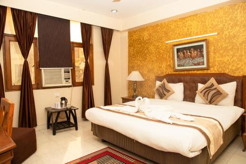 a bedroom with a large bed with towels on it at Hotel Angel in Greater Noida