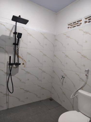 a bathroom with a toilet and a camera on the wall at FaqinHomestay in Pulau Sarang
