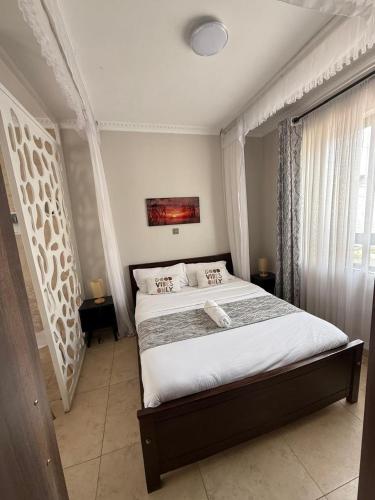 a bedroom with a large bed and a window at Modern Airport Studio apartment 5 mins to JKIA &SGR,Fast Wi-Fi,Ideal for layovers and longstays in Nairobi