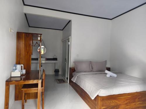 a bedroom with a bed and a desk and a table at FaqinHomestay in Pulau Sarang