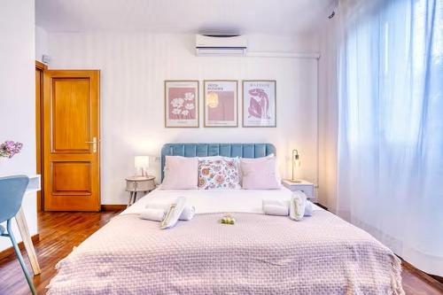 a bedroom with a large bed with a blue headboard at Private Parking & Garden -Luxury B&B-700mt Tower in Pisa