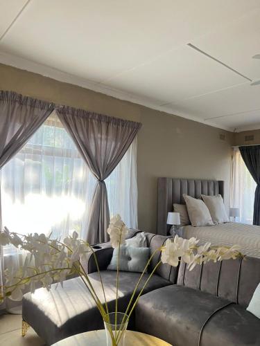 a living room with a couch and a bed at Garden Cottage - Self Catering in Amanzimtoti