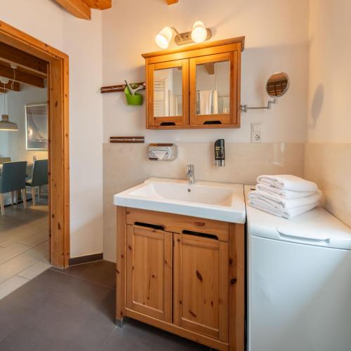 a bathroom with a sink and a washing machine at Nordsee-Apartments Hinrichsen in Husum