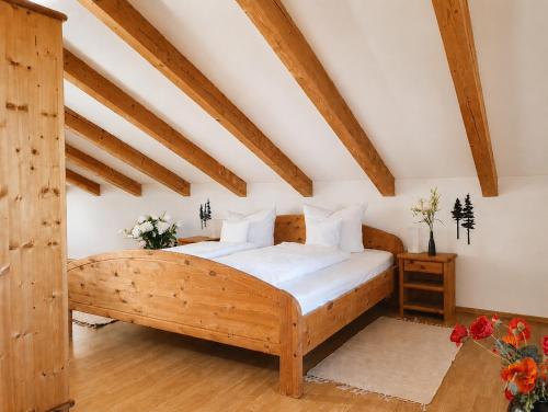 a bedroom with a wooden bed in a attic at Ferienwohnungen Stecher in Bad Endorf