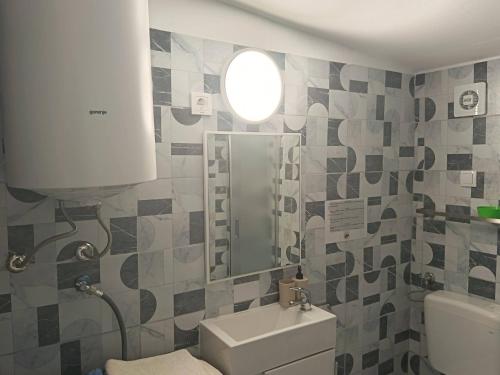 a bathroom with a sink and a toilet and a window at Apatmani Čriček in Vlašići