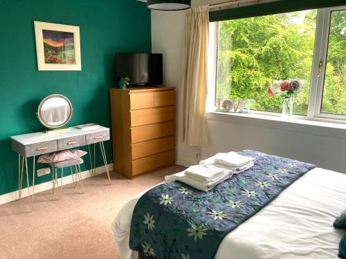 a bedroom with a bed and a dresser and a window at The Waterside Apartment 6 in Largs