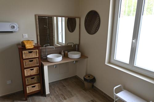 a bathroom with two sinks and a mirror at gîte MAELYSE in La Neuve-Lyre