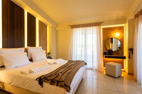 a bedroom with a large bed and a mirror at Zante Pantheon Hotel in Tsilivi