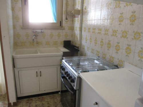 a kitchen with a sink and a stove at Appartamento Island Brioni in Grado-Pineta