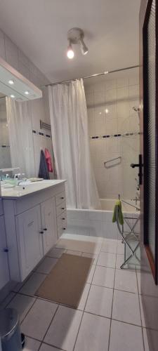 a white bathroom with a shower and a sink at Chambres d'hôtes - Bed & Breakfast - chez Denis-Jo in Toulon