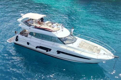 a white boat floating in the blue water at Riviera Marriott Hotel La Porte De Monaco in Cap d'Ail