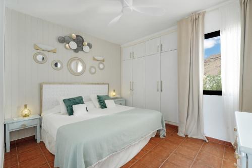 a white bedroom with a large bed and a window at Casa Amaoré in Alajeró