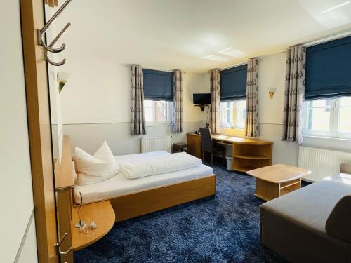 a hotel room with two beds and a desk at Landgasthof Meisel in Kalchreuth