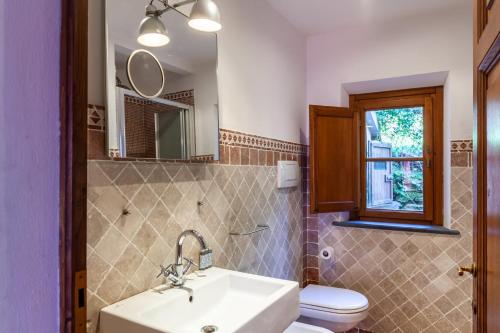 a bathroom with a sink and a toilet and a mirror at Podere Par di Rota in Calci