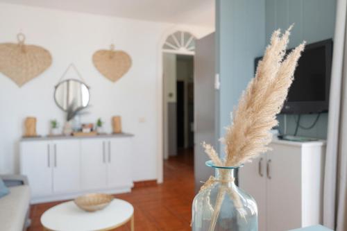 a glass vase with feathers in a living room at Casa Amaoré in Alajeró