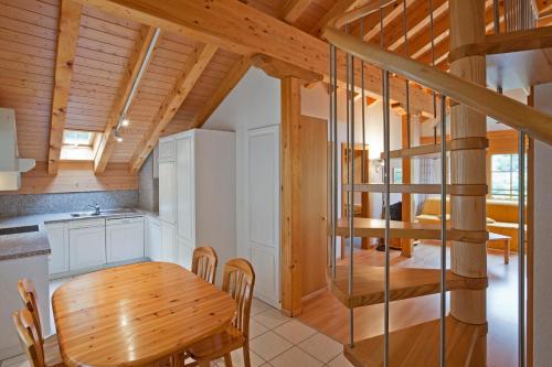 a kitchen and dining room with a wooden table and chairs at Les Naturelles in Leukerbad