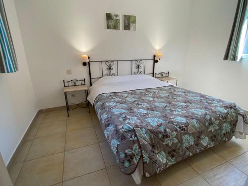 a bedroom with a bed and two night stands at Résidence Lagrange Vacances L'Oustau de Sorgue in L'Isle-sur-la-Sorgue