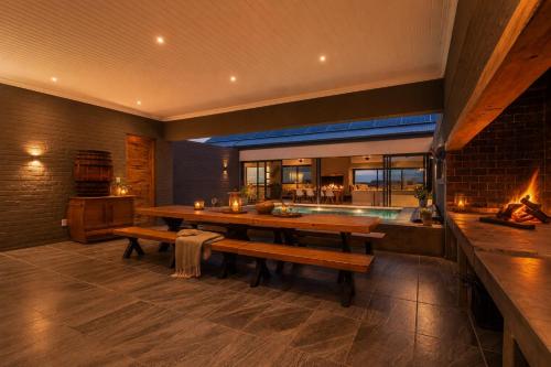 a dining room with a table and a fireplace at Cast Away at Romansbaai - Salted Fynbos Staying in Gansbaai