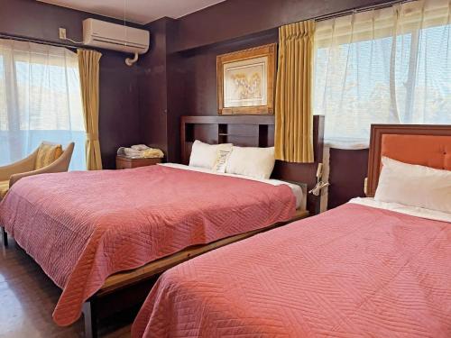 a hotel room with two beds with red sheets at Nikko Park Lodge Tobu Station in Nikko