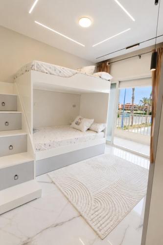a bedroom with white bunk beds and a rug at Porto Matrouh Elabd Family in Marsa Matruh