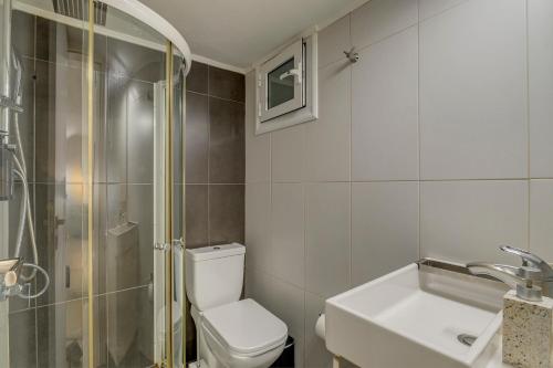 a bathroom with a toilet and a sink and a shower at Kalafatis Downtown Apartment in Itea