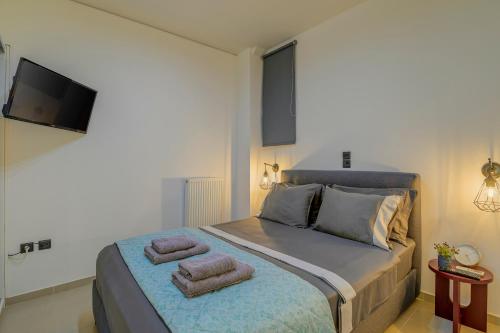 a bedroom with a bed with two towels on it at Kalafatis Downtown Apartment in Itea