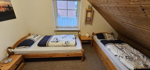 two twin beds in a room with a window at Medemstern I in Otterndorf
