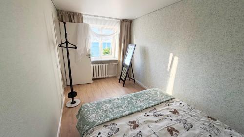 a bedroom with a bed and a window and a tripod at Vanilla Sunrise Apartments in Sillamäe