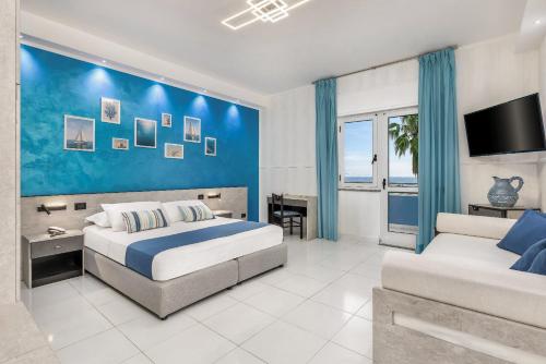 a bedroom with a bed and a blue wall at Hotel Blu Eden - Calabria oltre il mare in Praia a Mare
