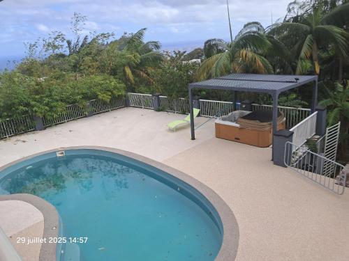 a large swimming pool with a gazebo on a patio at Villa melys in Petite Île