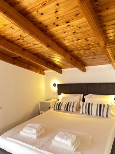 two beds in a bedroom with wooden ceilings at Paradises's Nest in Agios Georgios