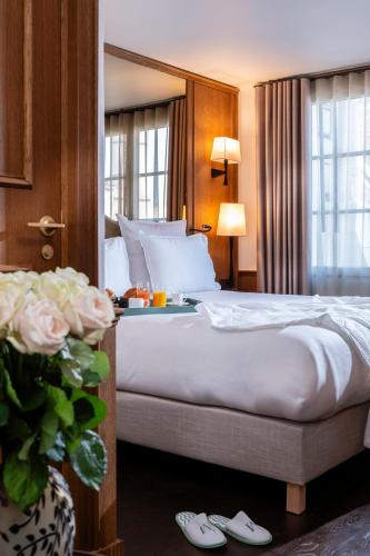 a hotel room with a bed and flowers in a room at Hôtel Villa Madame - Saint-Germain-des-Prés in Paris