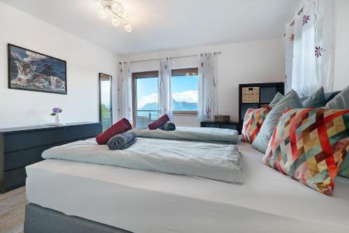 a large white bed in a room with windows at Villa Reny in Meltina