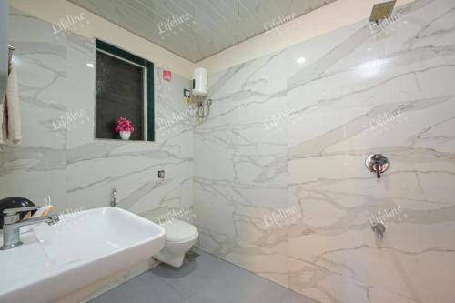 a white bathroom with a sink and a toilet at The Mariners Plunder - A Sea Facing Escape in Avas