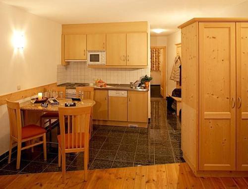 a kitchen with wooden cabinets and a table and chairs at Apart Ehart in Sankt Anton am Arlberg