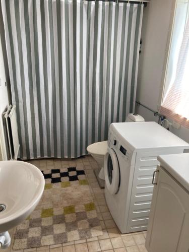 a bathroom with a shower and a washer and dryer at Gäststuga på Tjörn in Rösselvik