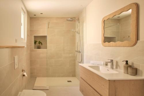 a bathroom with a shower and a sink and a mirror at Abri du vent, chambres et appartements in Fitou