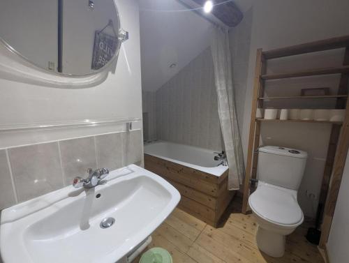 a bathroom with a sink and a toilet and a tub at De l'onde au vert in Vivey