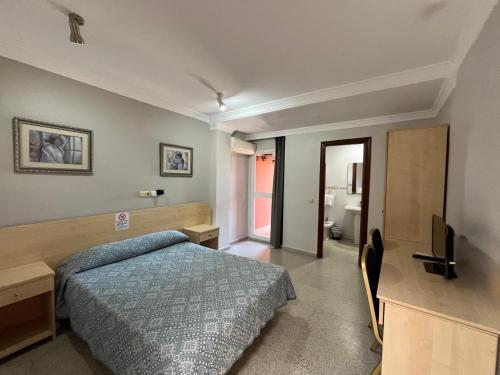 a bedroom with a bed and a flat screen tv at Hostal Blumen in Algeciras