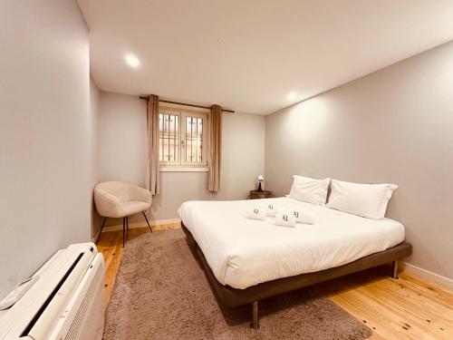 a bedroom with a large white bed with a window at Torrinha's Backyard in Porto