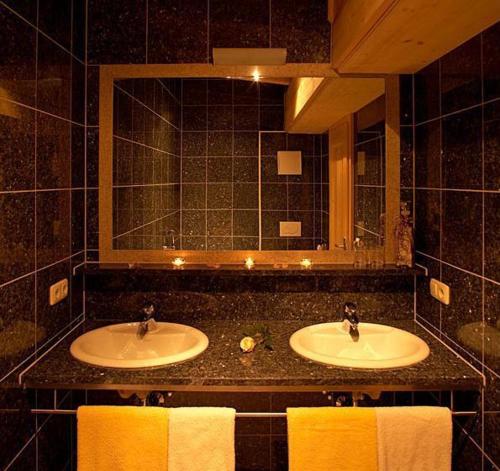 a bathroom with two sinks and a large mirror at Apart Ehart in Sankt Anton am Arlberg