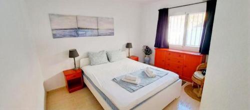 a white bedroom with a bed and a window at Casa Elletofft in Puerto de Mazarrón