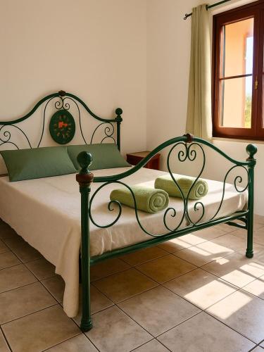 a green bed in a bedroom with a window at Casa Misè in Poggio Dei Pini